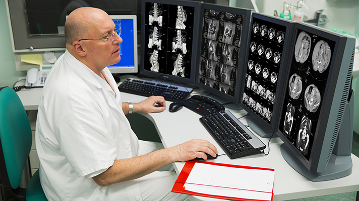 Senior radiologist of Oncology institute is examing MRI scans